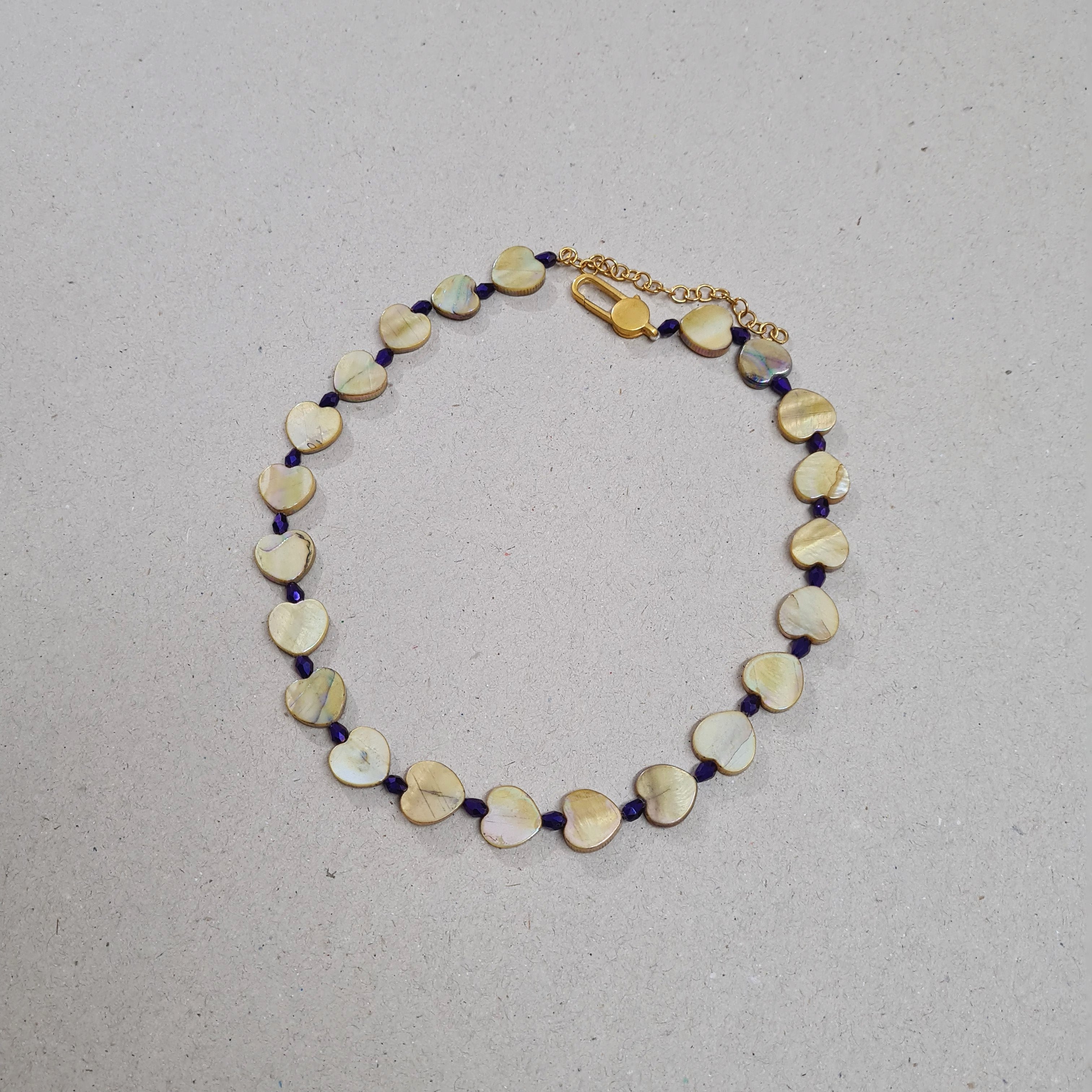 HEART SHAPED MOTHER OF PEARL BEADS IN GOLDEN GLOW SHINE WITH PURPLE CUT GLASS BEADS HAVE BEEN STRUNG TOGETHER TO MAKE THIS NECKLACE