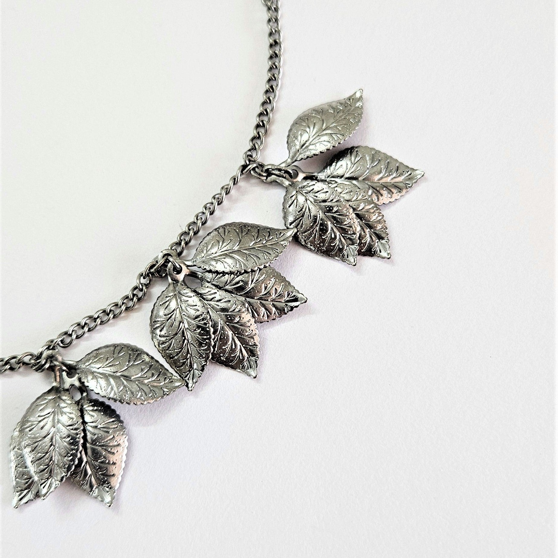 sculpted carved leaves handcrafted in brass are bunched together to create a garland like necklace